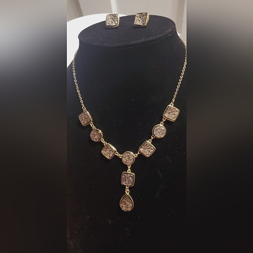 Golden tone faux smokey crystal segmented necklace with dangling center. 🌴